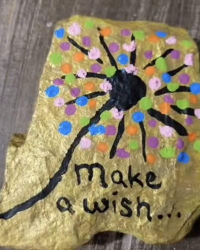 Small handpainted gold rock with a dandelion of colorful dots and the words Make a wish